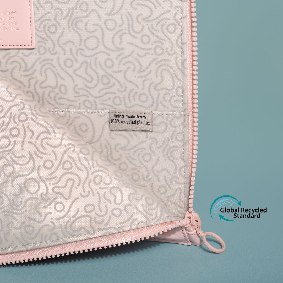 Close-up shot of the OneNine5 Komodo Pink laptop sleeve. The sleeve is open to show the grey patterned recycled plastic lining with the GRC logo overlaid on the image