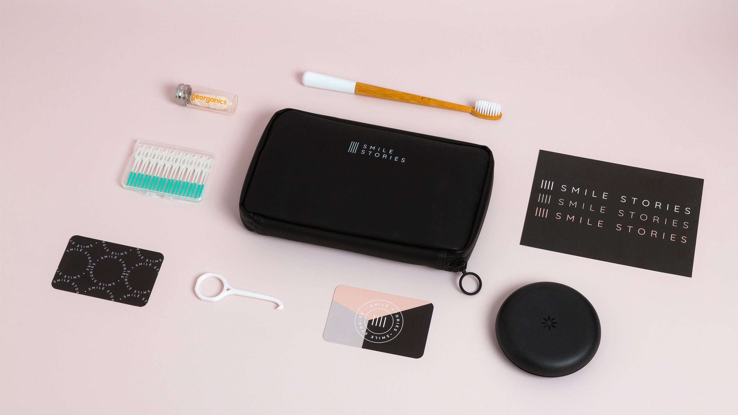 A Miho Black Eco Essentials Pouch, co-branded with a Smile Stories logo on the rear. Around the co-branded pouch are a range of dental products