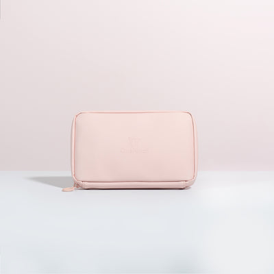 A front on view of the Komodo Pink Eco Essentials Pouch. Placed on a white surface with a pink background. The debossed OneNine5 logo is visible centrally on the front of the pouch.