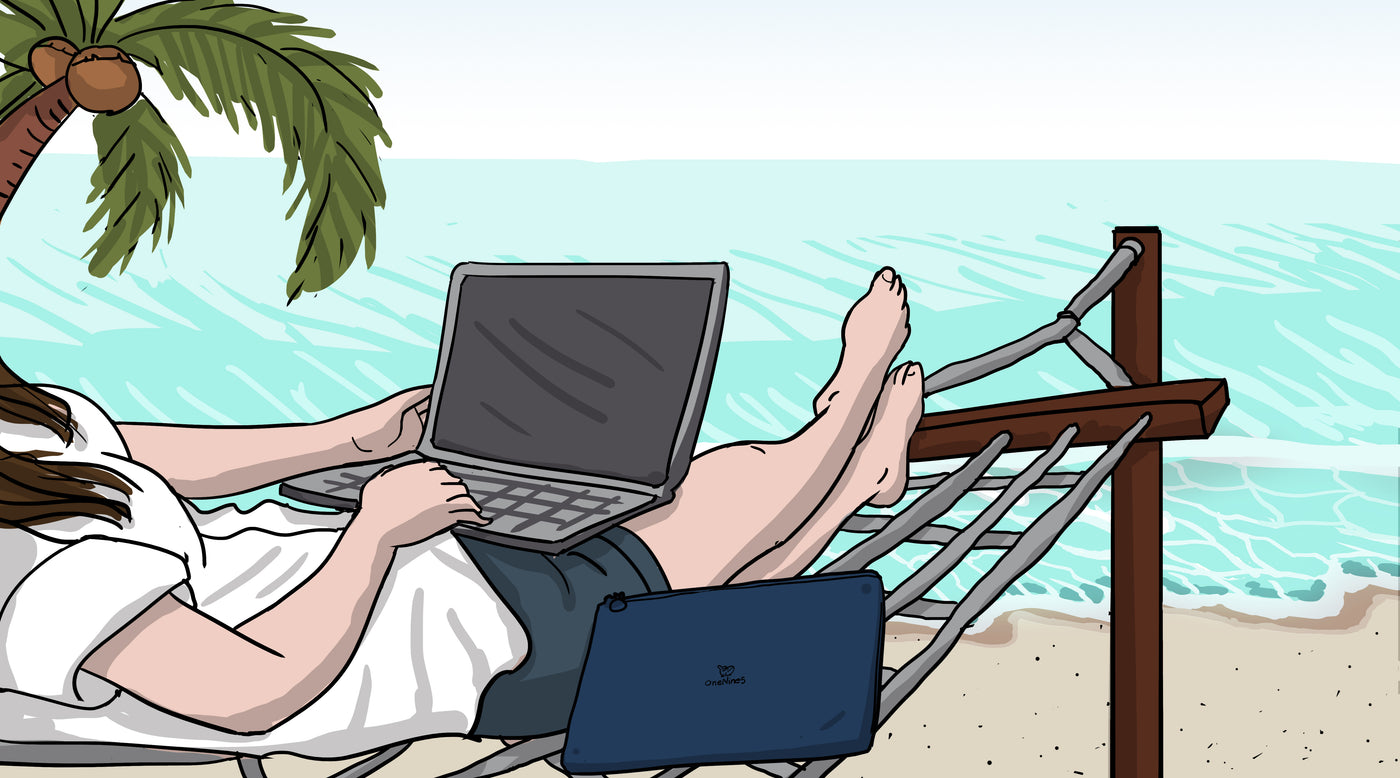 Woman sitting on hammock at beach working with laptop with palm tree in background with coconuts hanging. Beside her, a OneNine5 13" laptop sleeve.