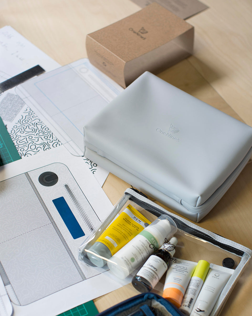 Birdseye image of a OneNine5 grey travel wash bag on a desk