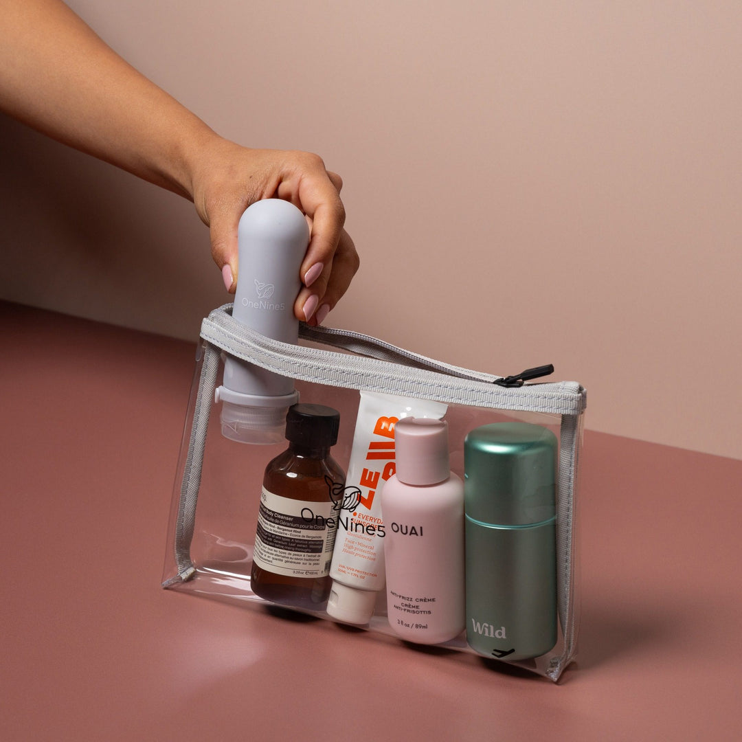 Hand packing toiletries into grey clear liquid pouch designed for airport liquids and carry-on travel