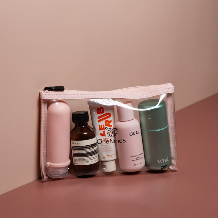Pink clear liquid travel bag filled with toiletries including bottles and skincare for easy airport security packing