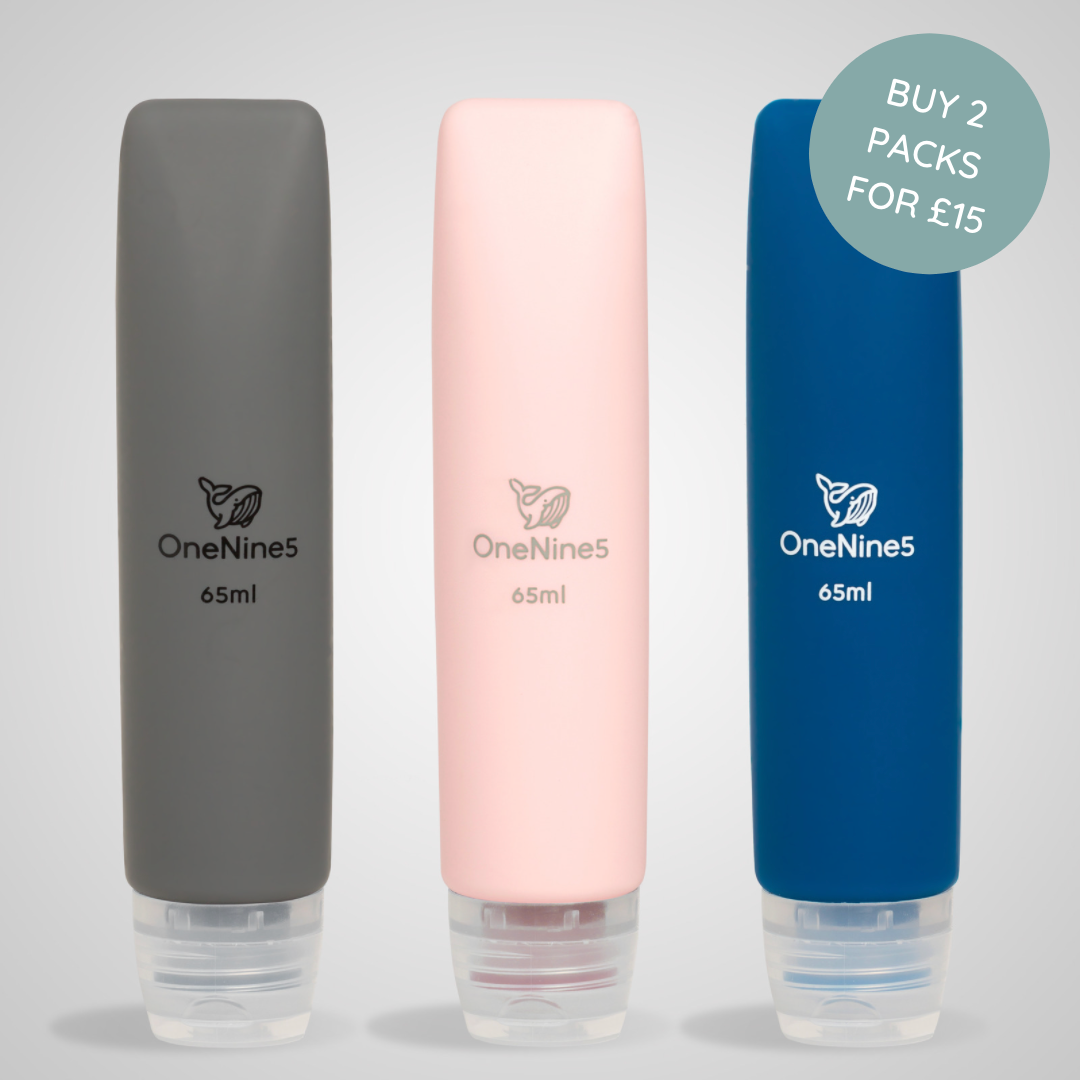 A grey, pink & blue OneNine5 silicone travel bottle on a grey background. A OneNine5 logo is visible on the front of the bottles that states a volume of 65ml.